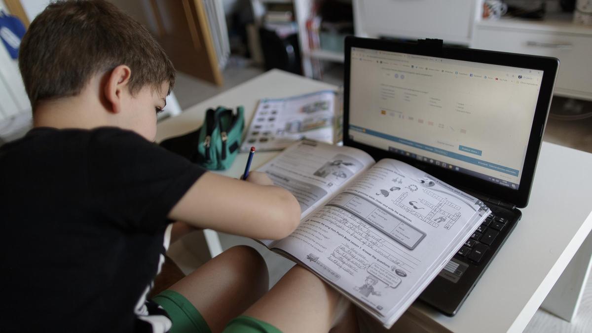 Un alumno realiza sus deberes sobre un libro de texto, en una imagen de archivo