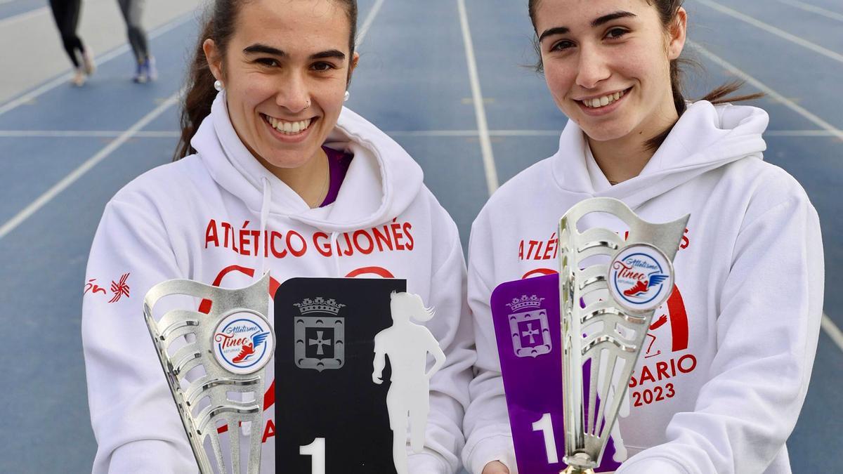 Por la izquierda, Olaya y Leyre Pérez, ayer, con sus trofeos, en la pista de atletismo de Las Mestas.