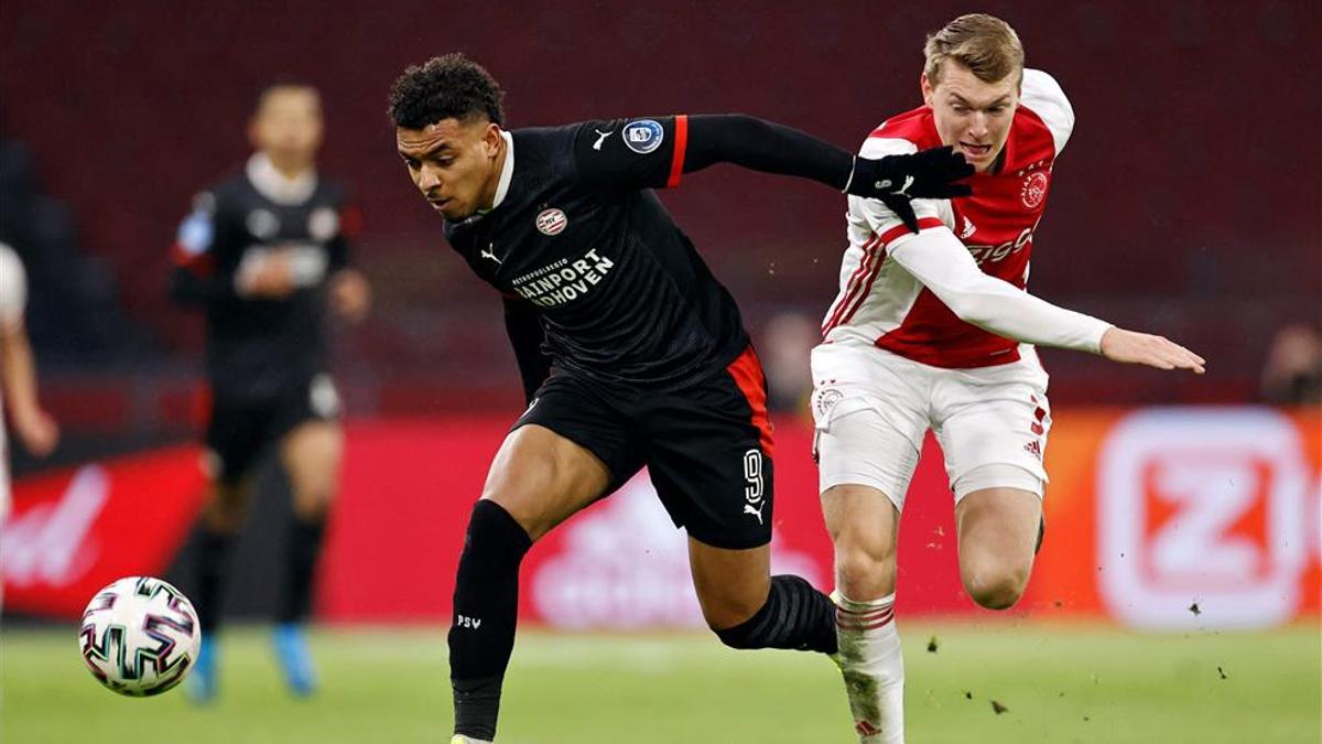 Malen y Schuurs pugnan por un balón durante el Ajax-PSV