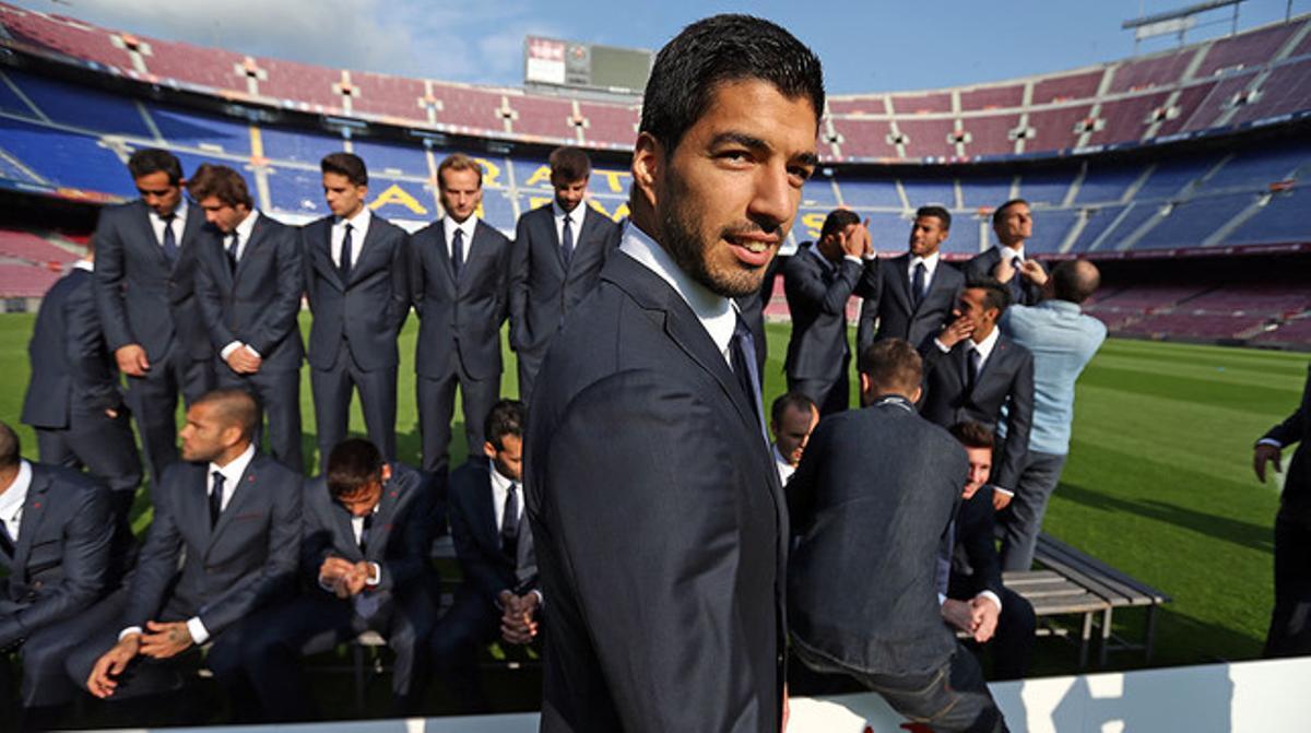 Suárez mira a la cámara antes de posar junto al resto de los jugadores con el traje de calle oficial.