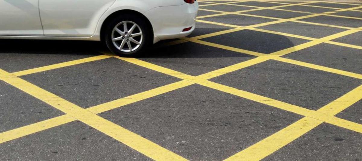 Un coche circulando sobre una cuadrícula amarilla