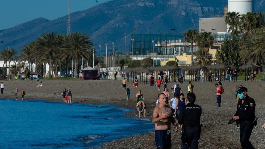 Un bañista, este sábado, advertido por una pareja de policías.