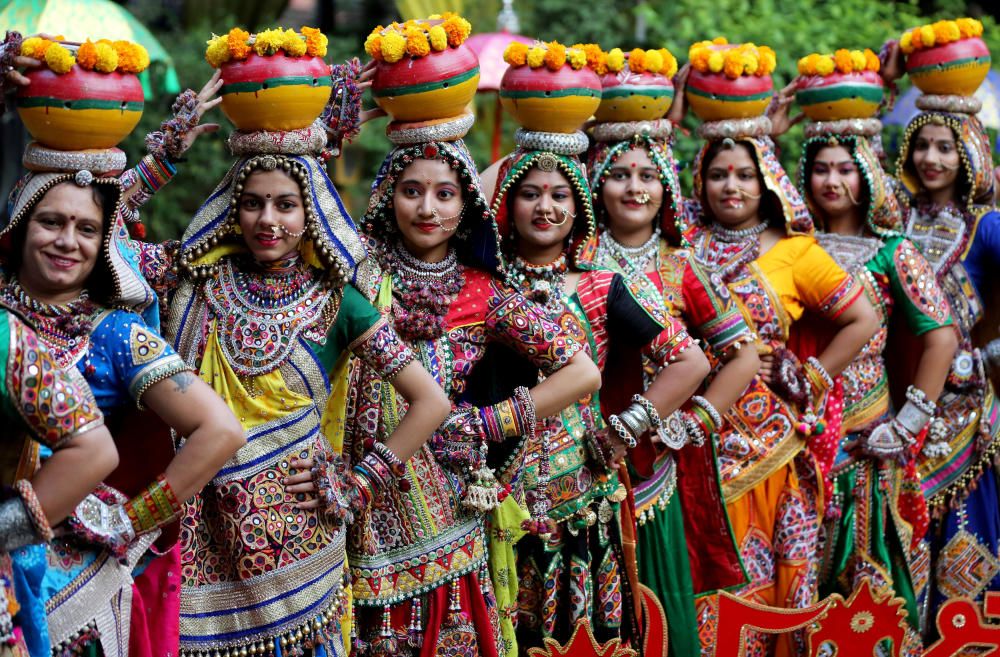 Women pose for pictures during rehearsals for ...