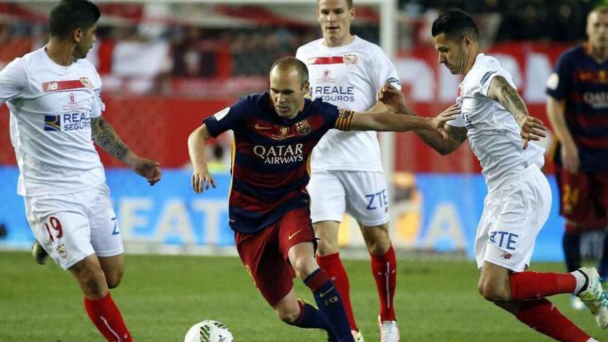 Iniesta con el balón, rodeado de jugadores del Sevilla.