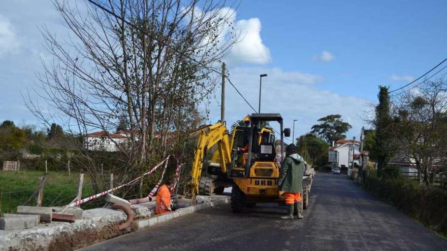 Operarios trabajando ayer en la acera de entrada a La Isla, levantada por segunda vez.