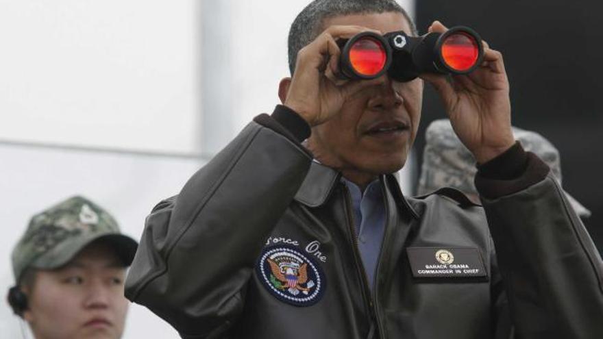 Obama mira por unos prismáticos hacia Corea del Norte en un puesto de observación en la zona desmilitarizada.