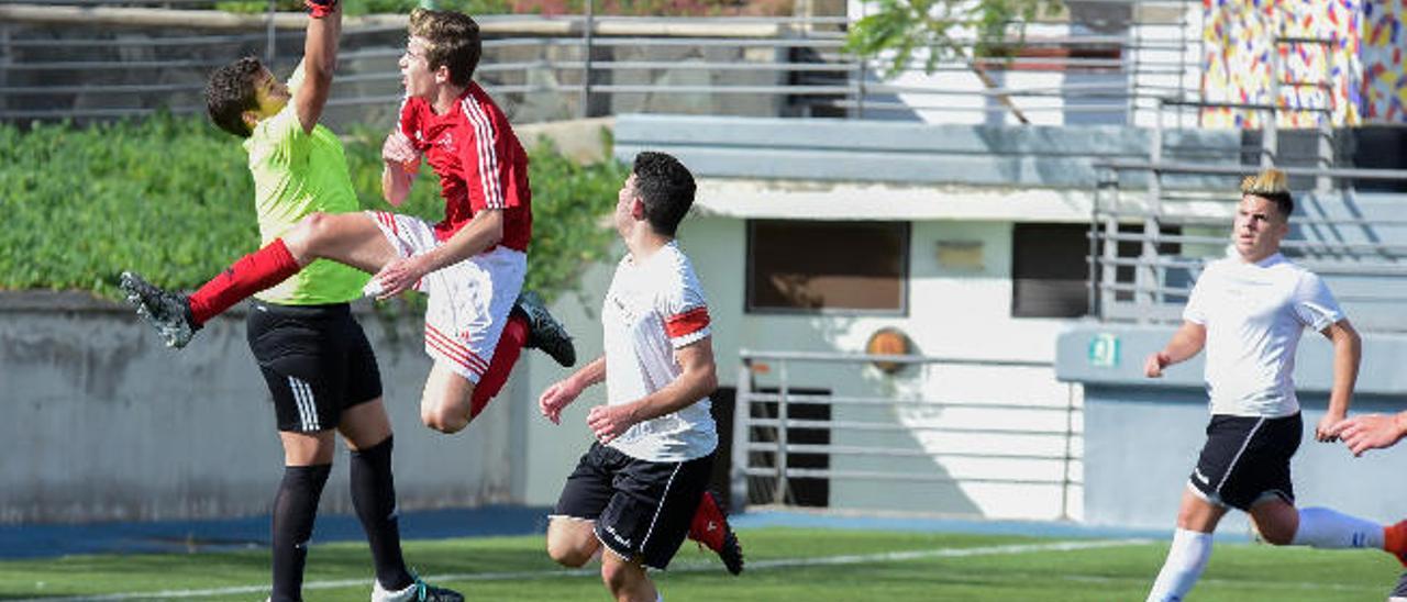 Carlos, portero del San Antonio, intercepta el balón al que intentaba llegar Kike. En la imagen junto al capitán Saúl.