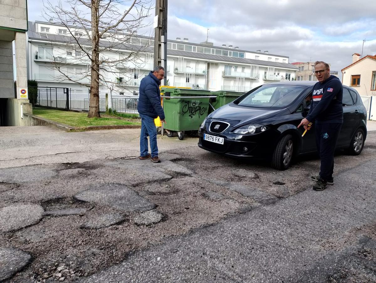 Otero y otro vecino miden los baches de la rúa Ponte Nova de Sabarís: 10 cm.
