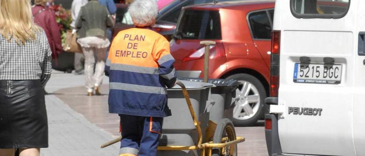 Una trabajadora del plan de empleo de Langreo en una céntrica calle de Sama.