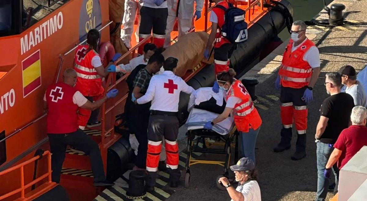 Uno de los supervivientes es conducido a la camilla, a su llegada al puerto de Cartagena.