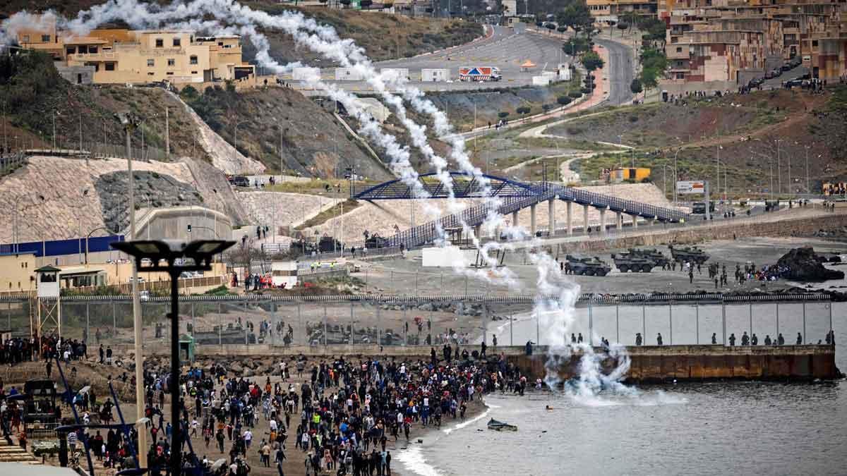 Fuerzas de seguridad españolas lanzan gases lacrimógenos en la valla fronteriza de la ciudad de Fnideq.