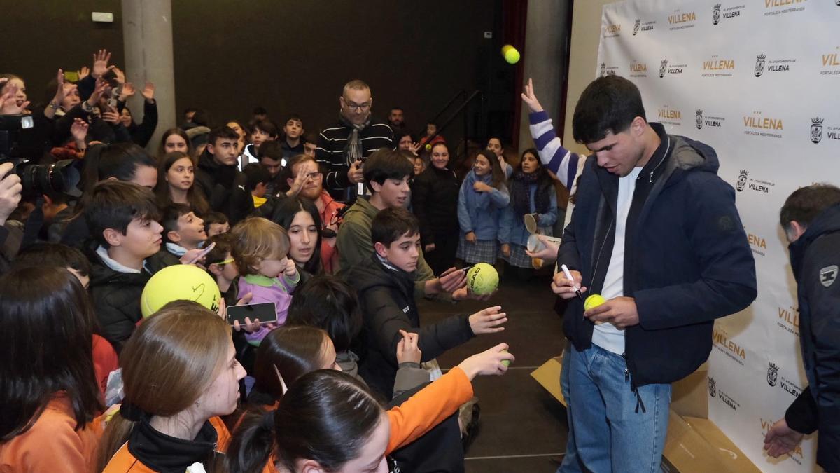 Carlos Alcaraz firmando pelotas a los niños y niñas.