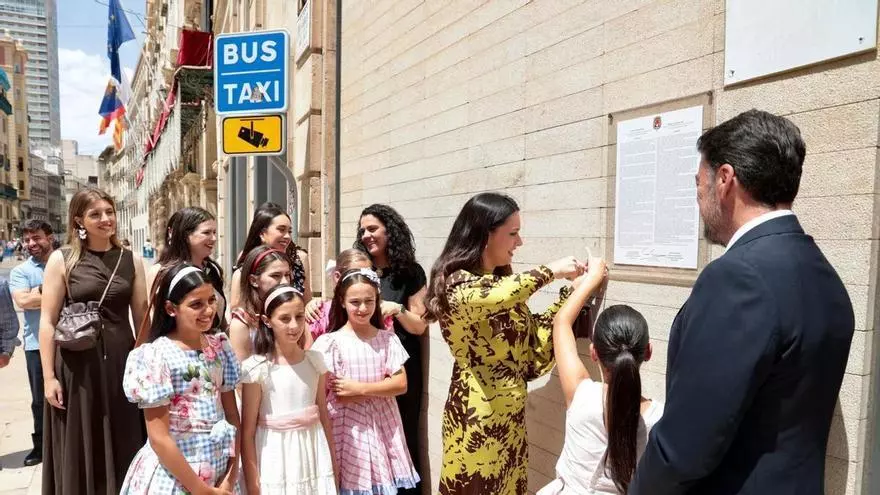 El alcalde de Alicante y la Bellea del Foc cuelgan el bando oficial de las Hogueras 2026 en la fachada del Ayuntamiento