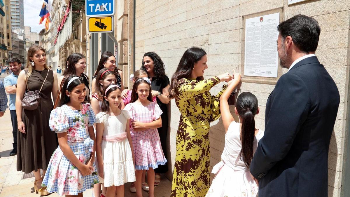 El alcalde de Alicante y la Bellea del Foc cuelgan el bando oficial de las Hogueras 2026 en la fachada del Ayuntamiento