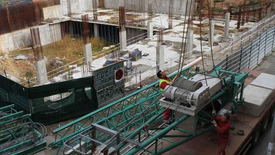 Los trabajadores instalan la grúa para cimentar la obra ya abandonada del Palacio de Congresos, en 2012.