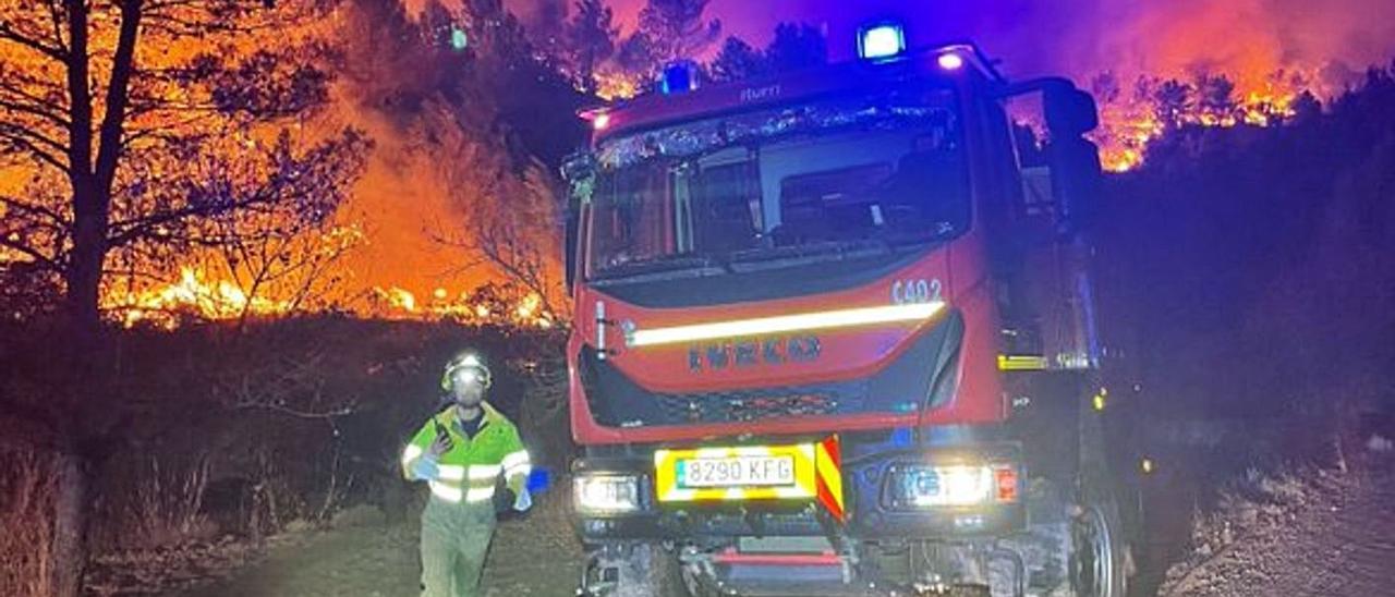 Un equipo de extinción, junto a una zona envuelta en llamas en Azuébar. | GVA