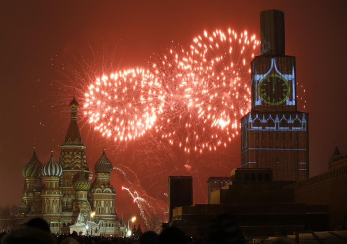 Els focs artificials il·luminen el cel davant la catedral de Sant Basil i el Kremlin, a Moscou.