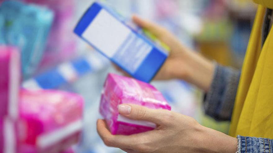 Una mujer elige tampones en un supermercado.