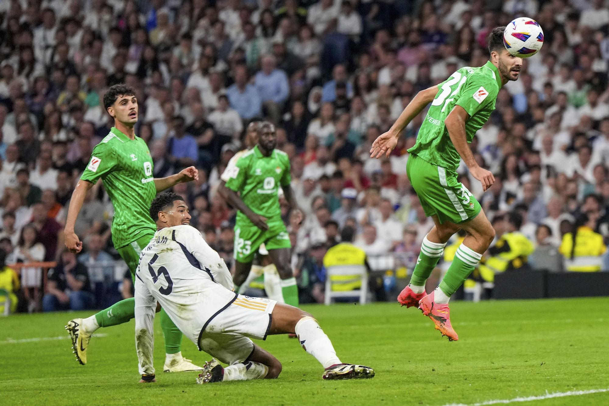 Real Madrid's Jude Bellingham, left, tries a shot during a Spanish La Liga soccer match between Real Madrid and Betis at the Santiago Bernabeu stadium in Madrid, Spain, Saturday, May 25, 2024. (AP Photo/Manu Fernandez)