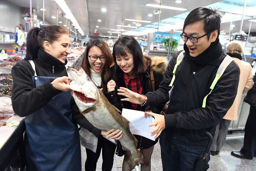 Una treintena de alumnos del Centro de Linguas de la Universidad coruñesa procedentes de China y Vietnam visitan el mercado de la plaza de Lugo para aprender argot gastrónomico gallego.