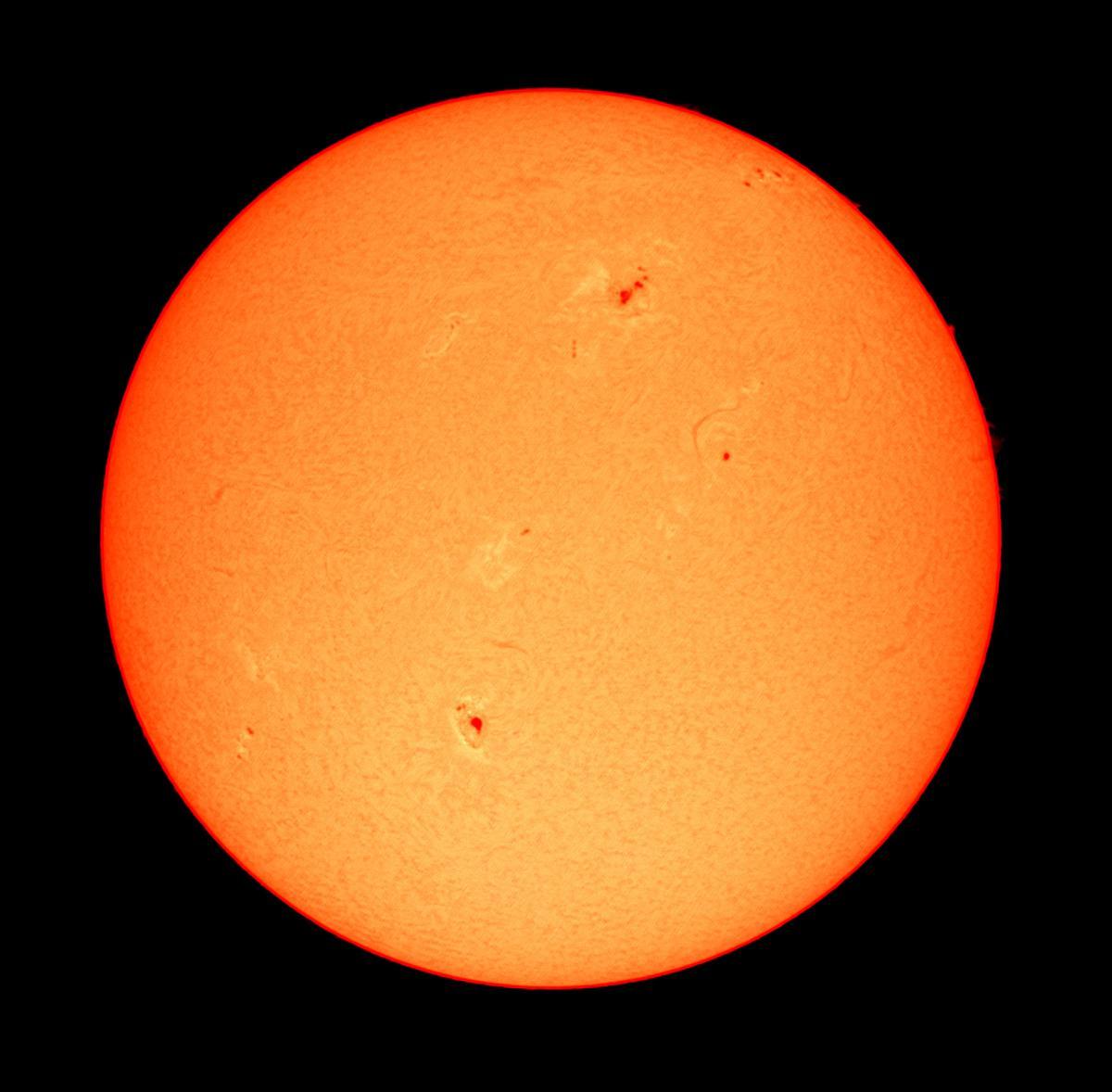 Vista del sol con telescopio solar en la que se pueden observar varias manchas solares.