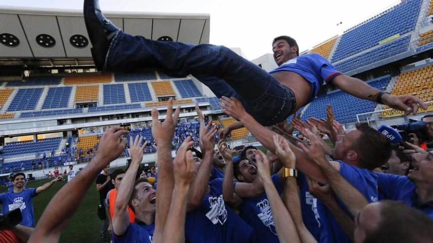 Los jugadores mantean a Arturo Elías tras lograr el ascenso en Cádiz.