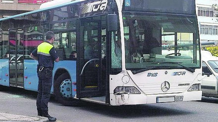 Un policía municipal, junto al autobús accidentado.