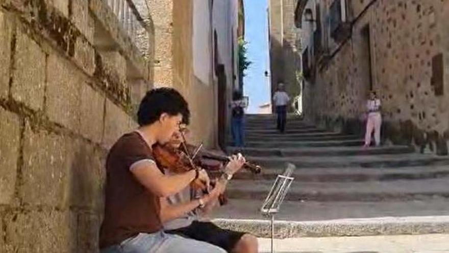 Video | Dos jóvenes violinistas sorprenden a los turistas en Cáceres con una versión de ‘Si te vas’, de Robe