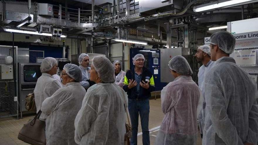 Un grupo de visitantes recibe explicaciones sobre el funcionamiento de la fábrica.