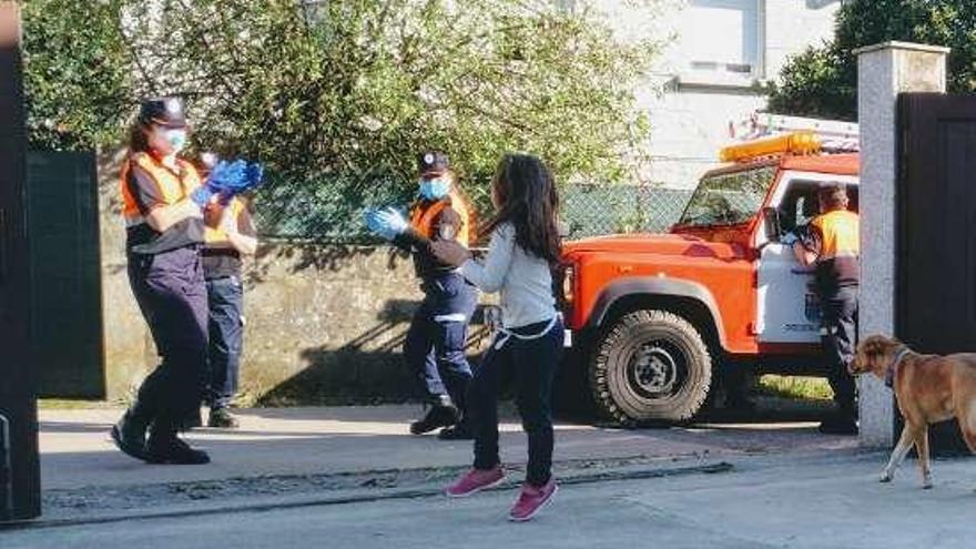 Miembros de Protección Civil felicitan a una niña en Salceda. // T.P.