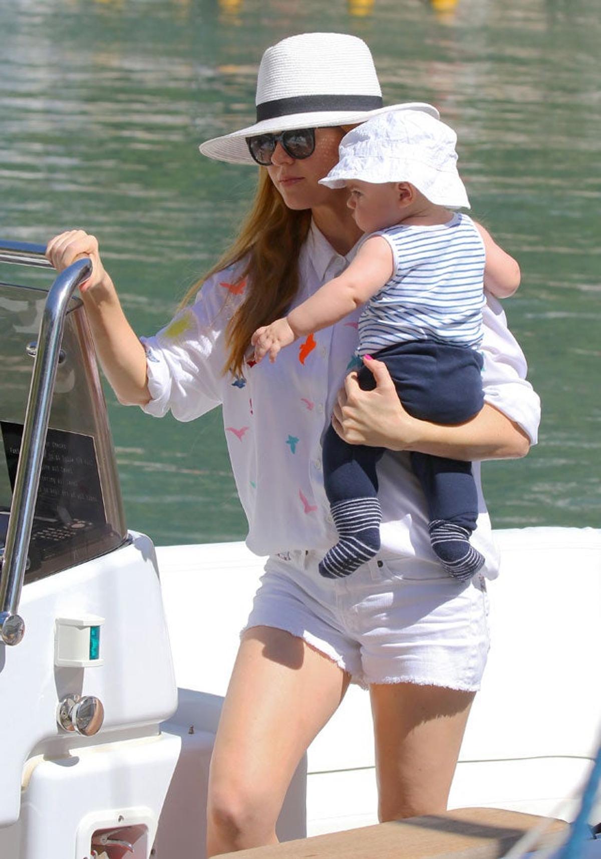 Isla Fisher apunto de salir de la lancha con su hijo en brazos