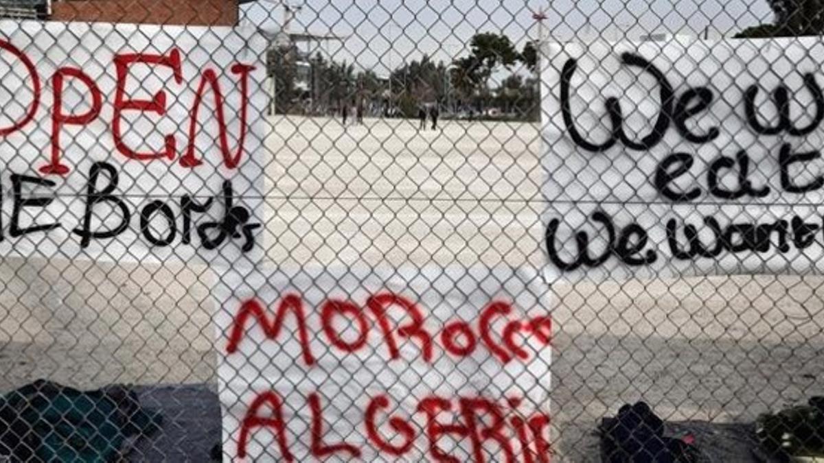 Pancartas de inmigrantes colgadas en las rejas de un antiguo recinto olímpico reconvertido en refugio temporal, en un suburbio de Atenas, este martes.