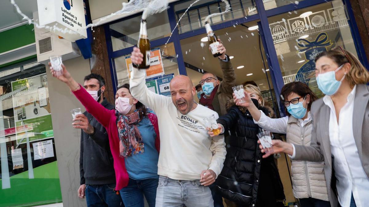 Arriba, en el centro, Carlos Fernández, celebra el premio con el personal de la administración avilesina de Fernández Balsera. 