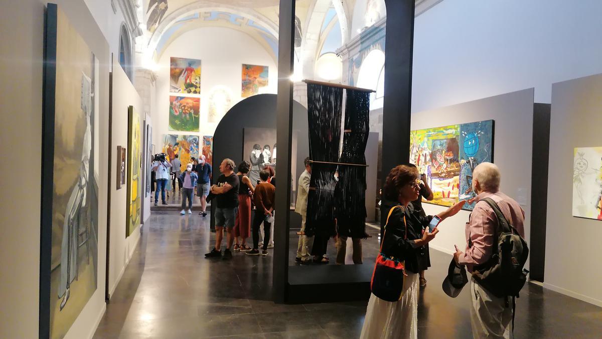 Visitantes admiran las obras de la muestra que se exhiben en la iglesia de San Agustín