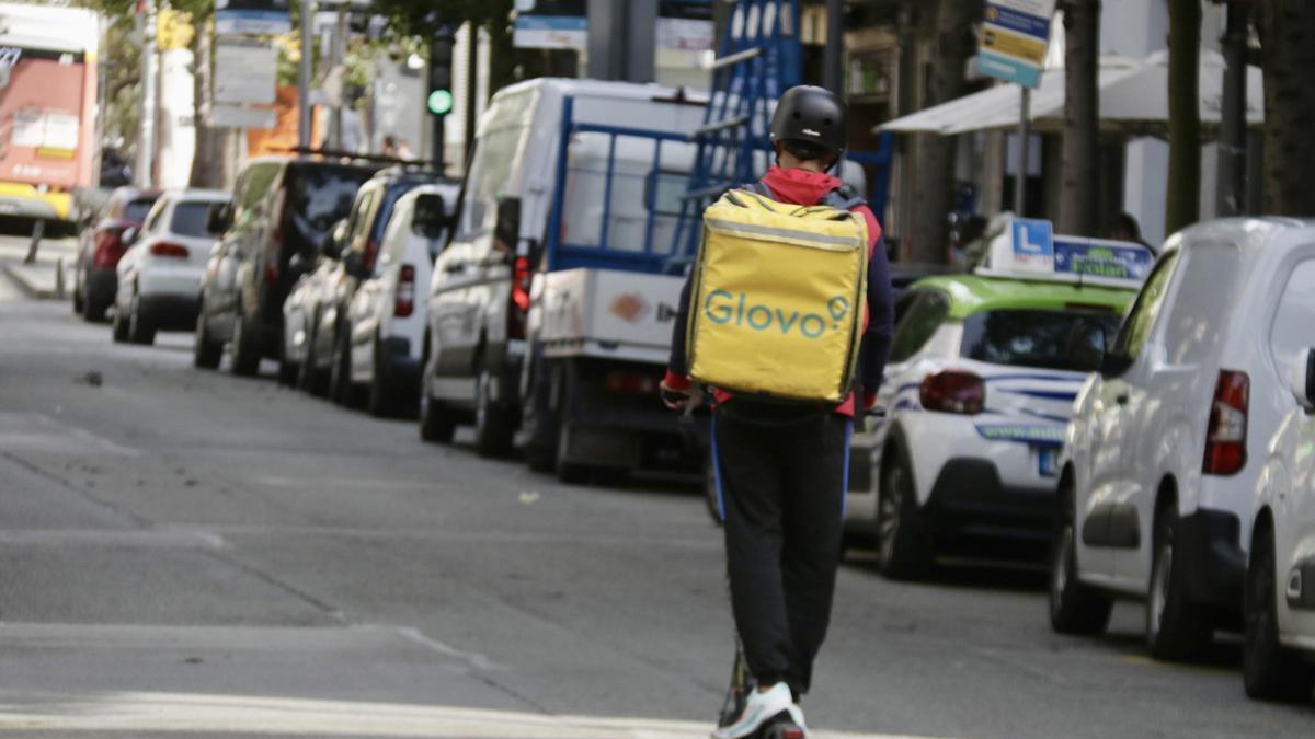 Un repartidor de Glovo desplaçant-se en patinet.