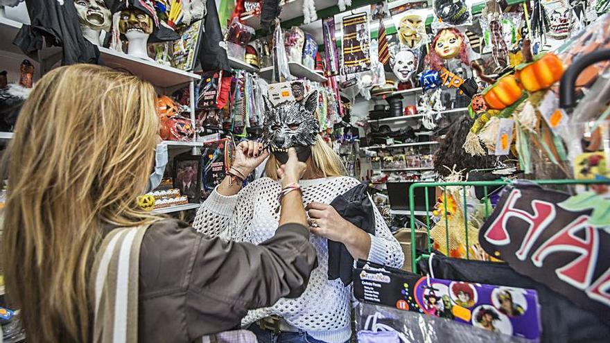 Dos jóvenes se pruebas máscaras para Halloween. | PILAR CORTÉS