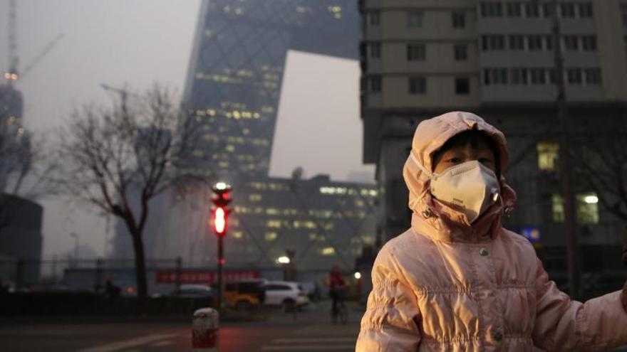 Una niña usa una mascarilla para protegerse de la contaminación.