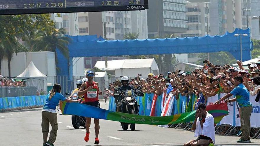 Alberto Suárez Laso cruza la meta de la maratón de Río en segundo lugar, con el ganador, el marroquí Chentouf, a la derecha, arrodillado.