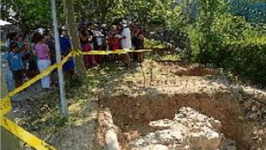 Restes arqueològiques i participants en una visita guiada al castell