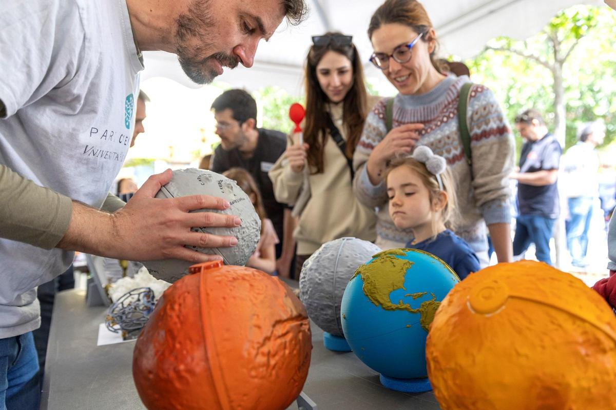 Una xiqueta observa un globus terraqüi a Expociència 2025