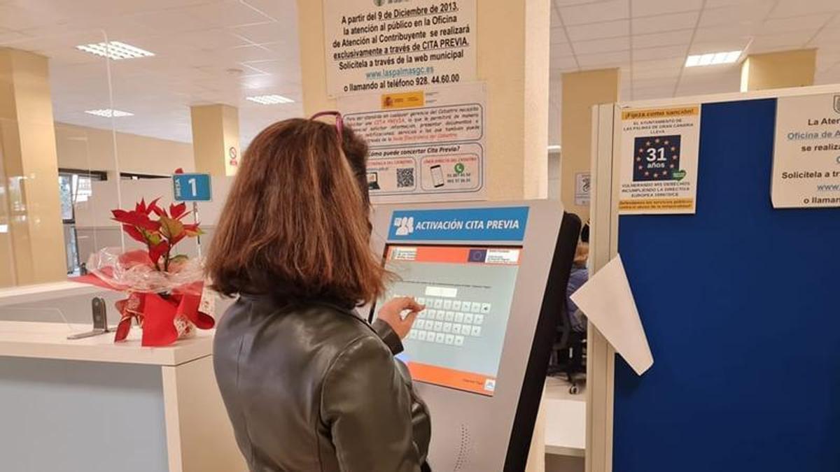 Una mujer realiza un trámite en un quiosco del Ayuntamiento de Las Palmas de Gran Canaria.