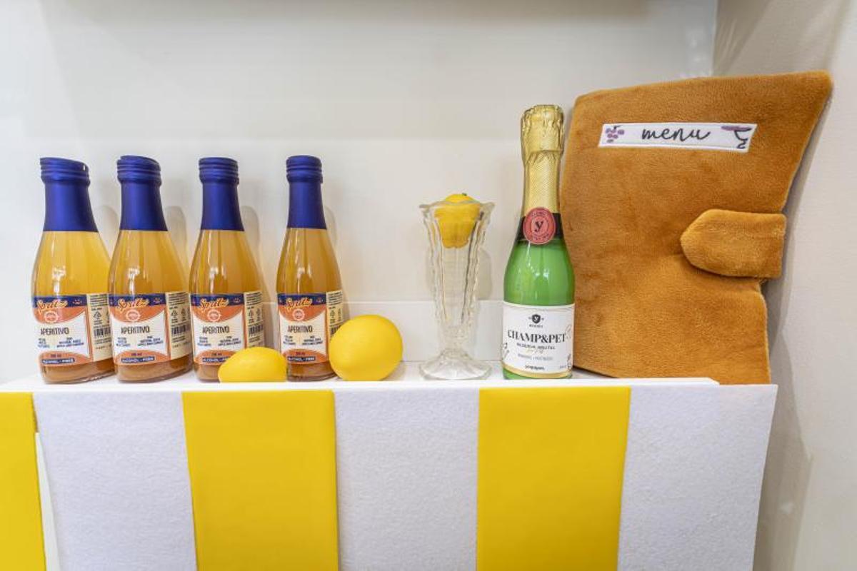 Botellitas de Spritz de aperitivo para perros y un benjamín de champán en una estantería de Voilà.