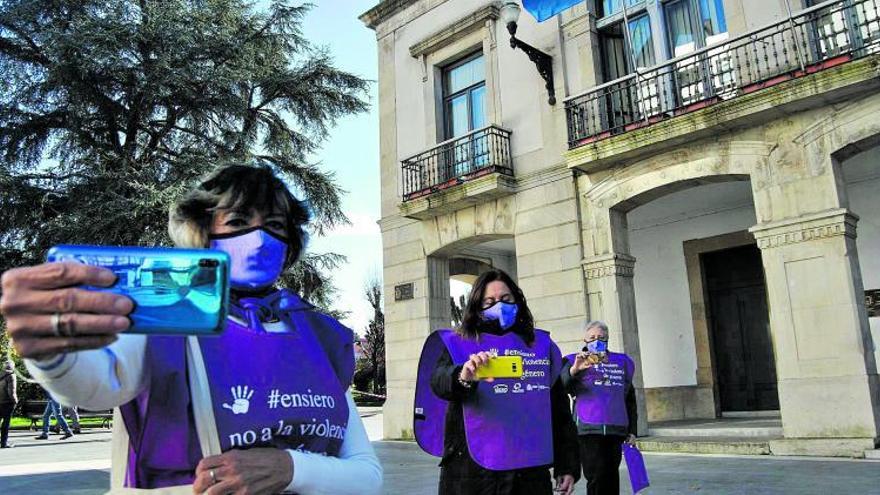 Por la izquierda, María José Prieto, Eva María Montes y Ángeles Prada, grabando un vídeo para la marcha virtual de Siero, en la plaza del Ayuntamiento de la Pola. | A. I.