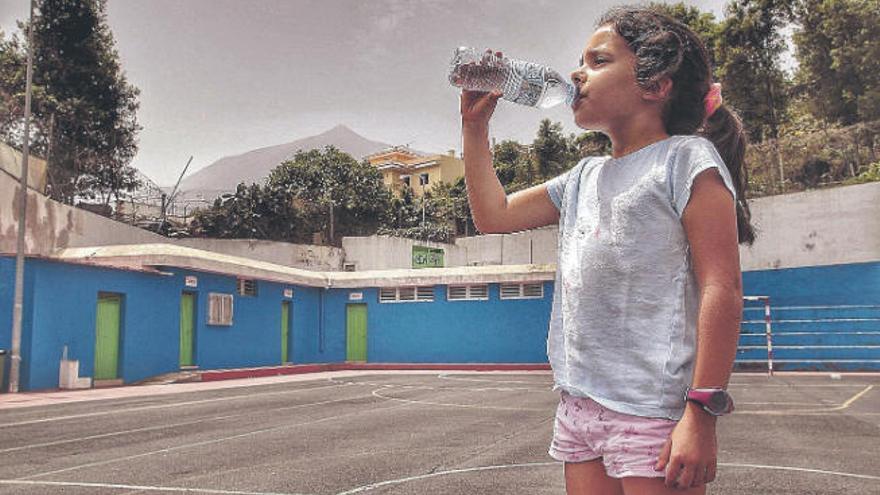 Una niña toma agua en un polideportivo de Icod de los Vinos en un día de calor y calima.