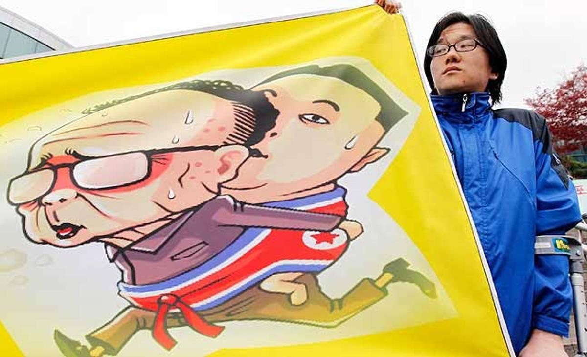 Un manifestant sosté una pancarta amb una caricatura del líder nord-coreà Kim Jong-il carregant el seu fill i aparent hereu Kim Jong-un durant un míting demanant una legislació sobre drets humans per a Corea del Nord, a Seül (Corea del Sud).