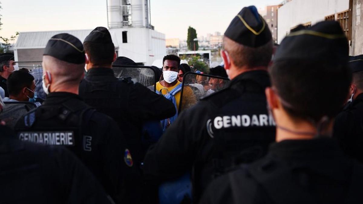 La policía contine a los inmigrantes durante la evacuación del campamento en Aubervilliers, cerca de París.
