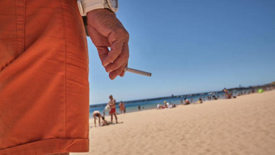 Un bañista fuma en la playa de Las Teresitas, en Santa Cruz de Tenerife.