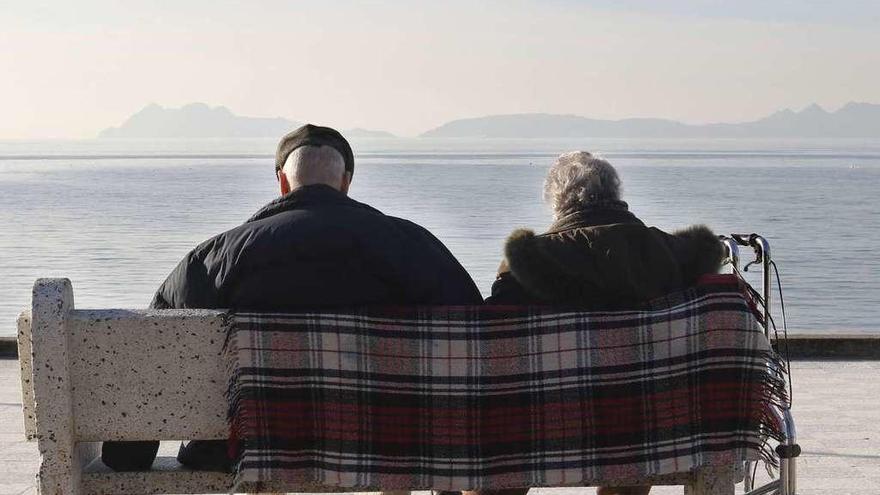 Dos personas disfrutan del buen tiempo, ayer en el paseo de Samil, en Vigo. // Alba Villar