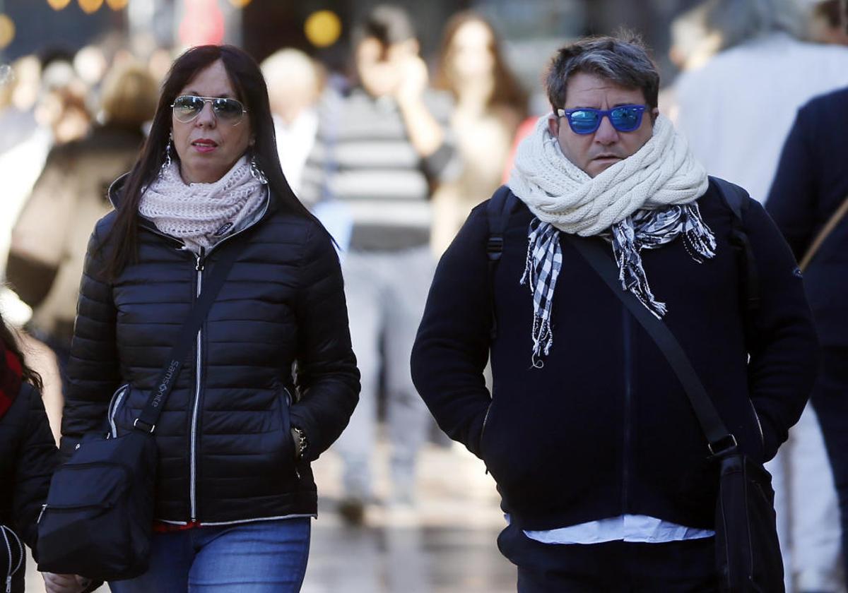 Una pareja pasea bien abrigada por Valencia.