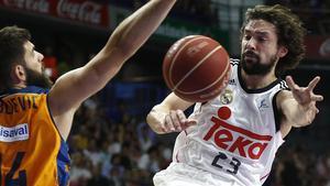 El base del Real Madrid Sergio Llull (d) recibe un pase ante el pívot del Valencia Basket Bojan Dubljevic (i) durante el partido de playoff de semifinales de la Liga Endesa 